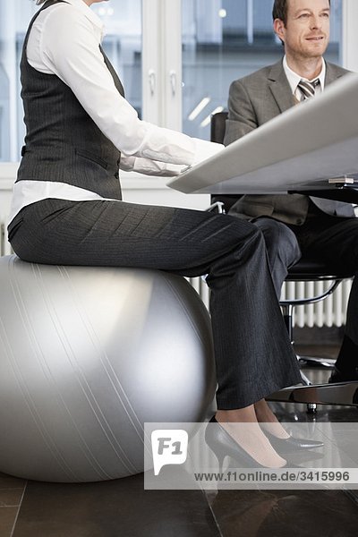 Geschäftsfrau auf dem Gymnastikball sitzend
