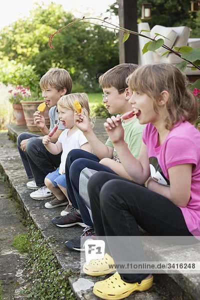 Kinder genießen Eis am Stiel im Freien