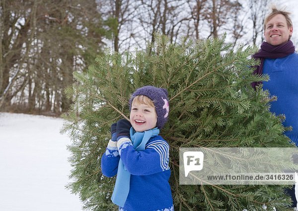 Vater und Sohn mit Weihnachtsbaum