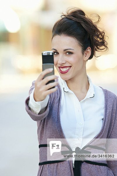 Eine Frau macht ein Foto auf ihrem Handy.