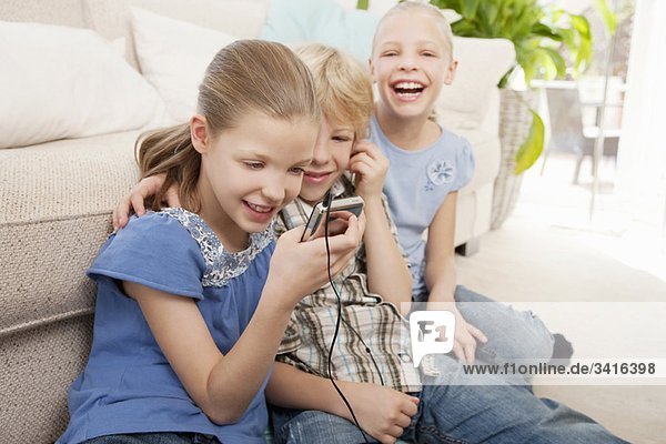 Kinder spielen mit einem MP3-Player