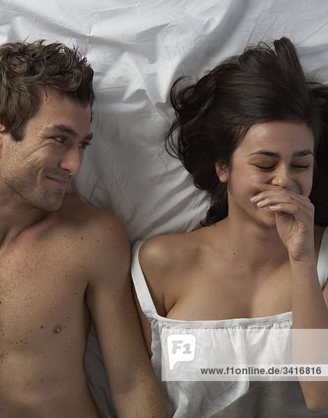 Junges Paar im Bett lacht  hoher Winkel
