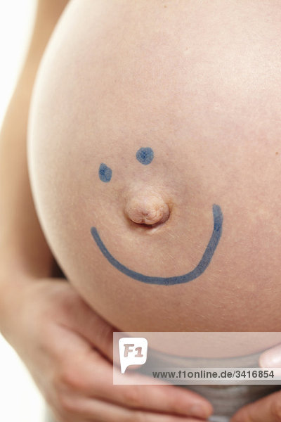 Schwangerer Bauch mit Smiley-Gesicht