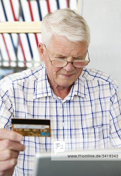 Mann mit Kreditkarte und Laptop