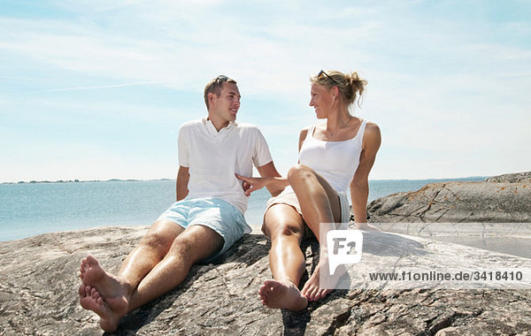 Junges Paar auf den Felsen sitzend