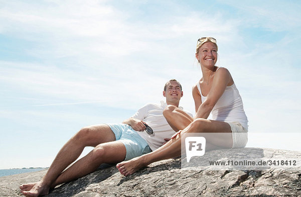 Two young people sitting on the beach