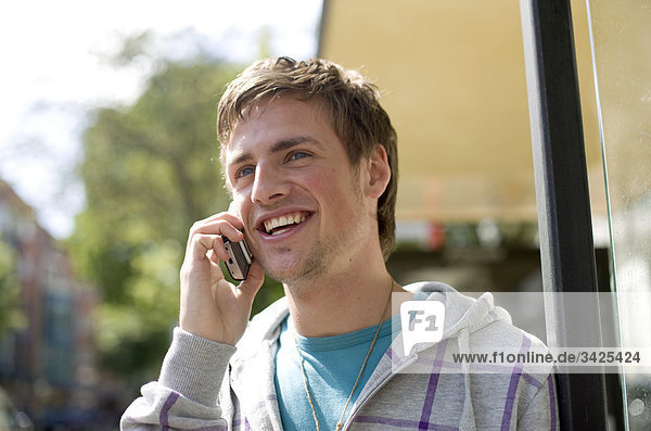 Young man talking on mobile phone  low angle view