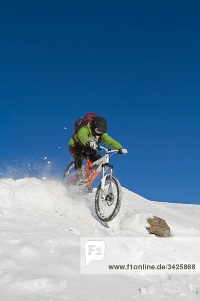 Man mountainbiking on snow