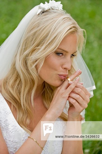 Die Braut küsst ihren Ehering.