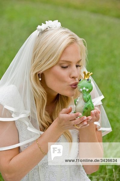 Braut küssender Spielzeugfrosch.