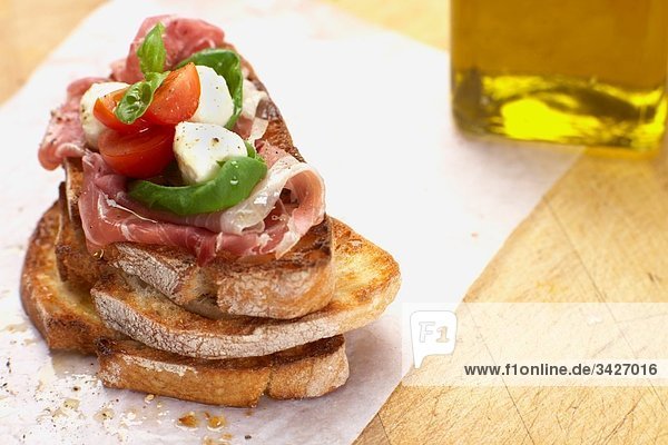 Gebratenes Sandwich mit Parmaschinken  Mozzarella  Tomaten und Basilikum  Nahaufnahme