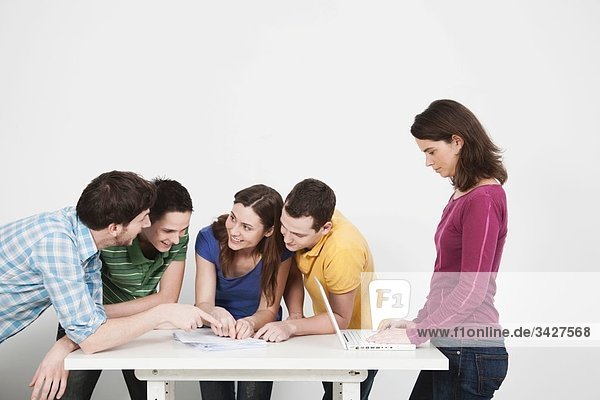 Freunde diskutieren und benutzen den Laptop.