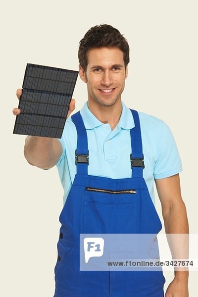Mann mit Solarzelle  lächelnd  Portrait