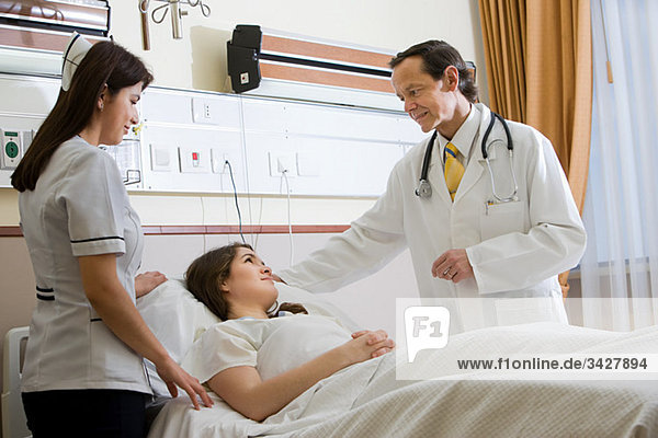 Woman in hospital with doctor and nurse