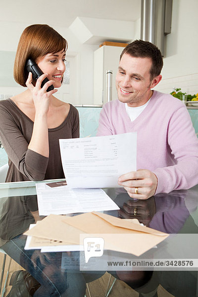 Couple on telephone with bills