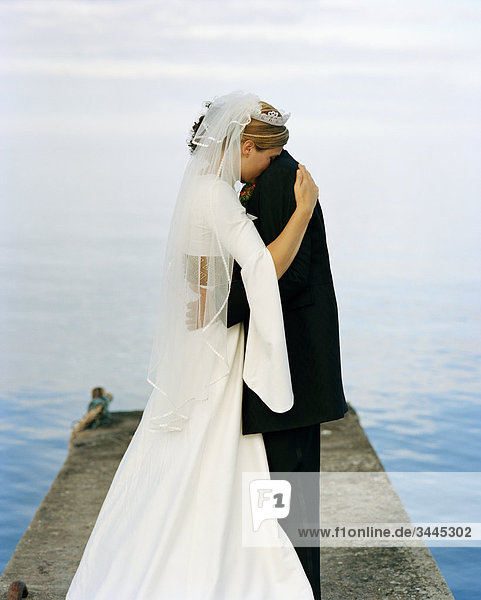 Skandinavien  Schweden  Oland  Bräutigam und Braut umarmen auf jetty