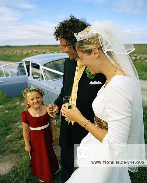 Skandinavien  Schweden  Oland  Braut und Bräutigam mit Blumen-Mädchen  lächelnd