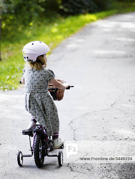 Scandinavia  Sweden  Stockholm  Girl riding bicycle  rear view