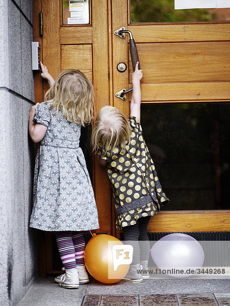 Scandinavia  Sweden  Stockholm  Girls pushing doorbell  rear view