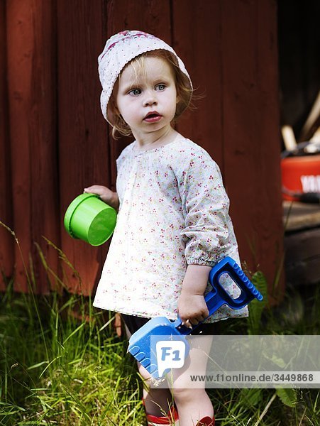 Skandinavien  Schweden  Girl (2-3) hält Spielzeug Spaten und Eimer
