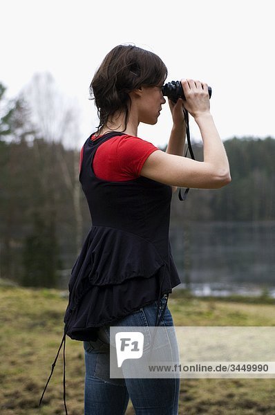 Woman using binoculars  Sweden.