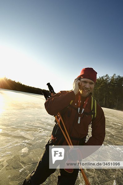 Ein Mann sprechen im Handy und Eislaufen