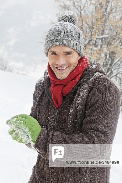 Young man making a snowball