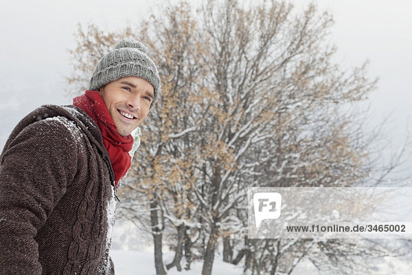 Young man in winter clothes smiling at camera