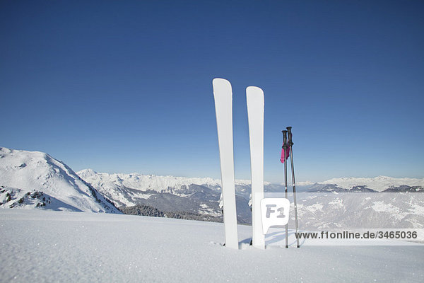 Skier und Skistöcke im Schnee stecken geblieben