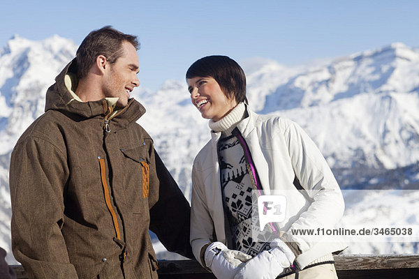 Junges Paar schaut sich an  Berge im Hintergrund