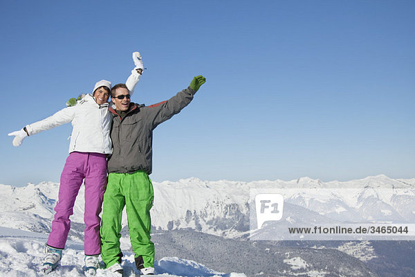 Junges Paar in Skikleidung lächelnd vor der Kamera
