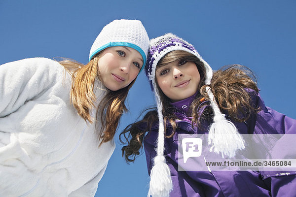 Zwei Teenagermädchen in Winterkleidung  lächelnd vor der Kamera