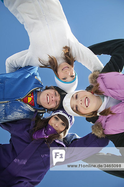 Vier Teenager in Skikleidung  lächelnd vor der Kamera