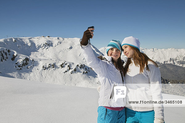 Zwei Teenagermädchen in Skikleidung  die sich selbst porträtieren.