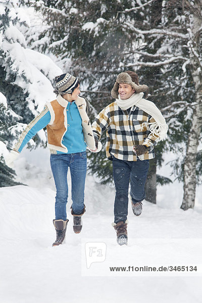 Young couple running in snow