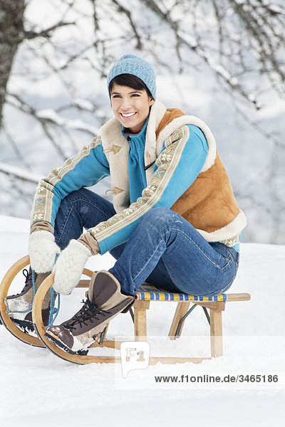 Young woman sitting on sled