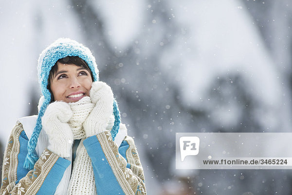 Junge Frau in Winterkleidung schaut nach oben