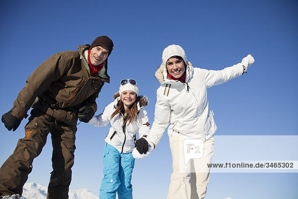 Couple and daughter in ski wear smiling at camera