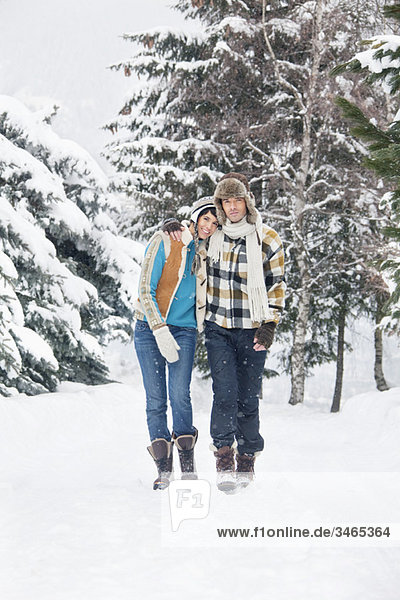 Young couple embracing,  walking in snow
