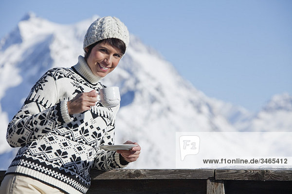 Junge Frau trinkt Kaffee  Berge im Hintergrund