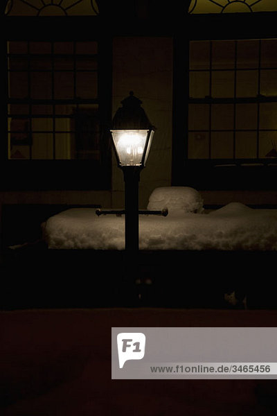 An illuminated street lamp at night in winter