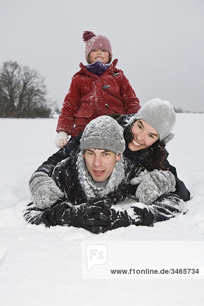 A family of three playing the in the snow