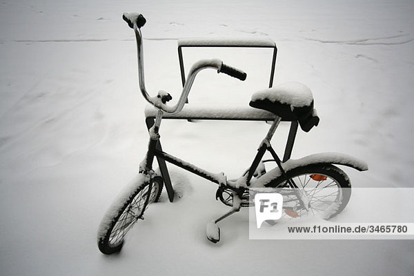 A bicycle covered in snow