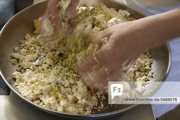 A woman mixing dough with her hands  detail of hands