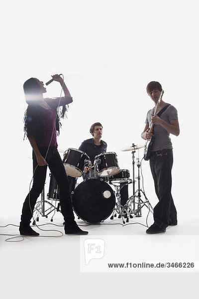 Schlagzeuger  Gitarrist und Sänger  Studioaufnahme  weißer Hintergrund  hintergrundbeleuchtet