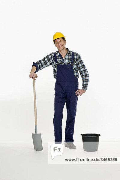 A construction worker posing with a shovel and bucket