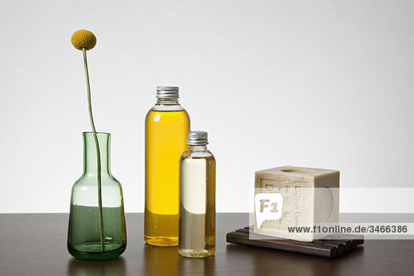 Aromatherapieöl  ein Stück Seife und eine Vase mit einer Billybutton Daisy (Craspedia)