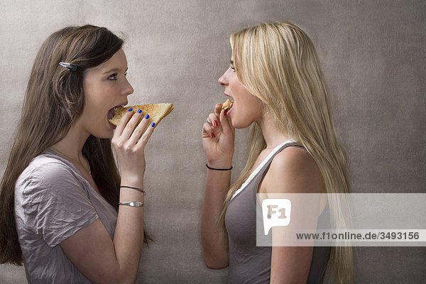 Teen girls eat sandwiches