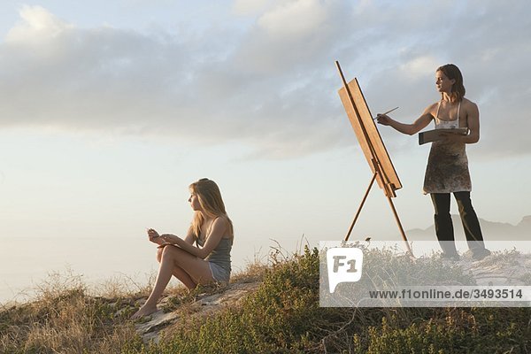 Junger Mann malt mit junger Frau