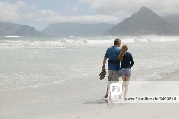 Junge Frau geht mit Vater am Strand spazieren